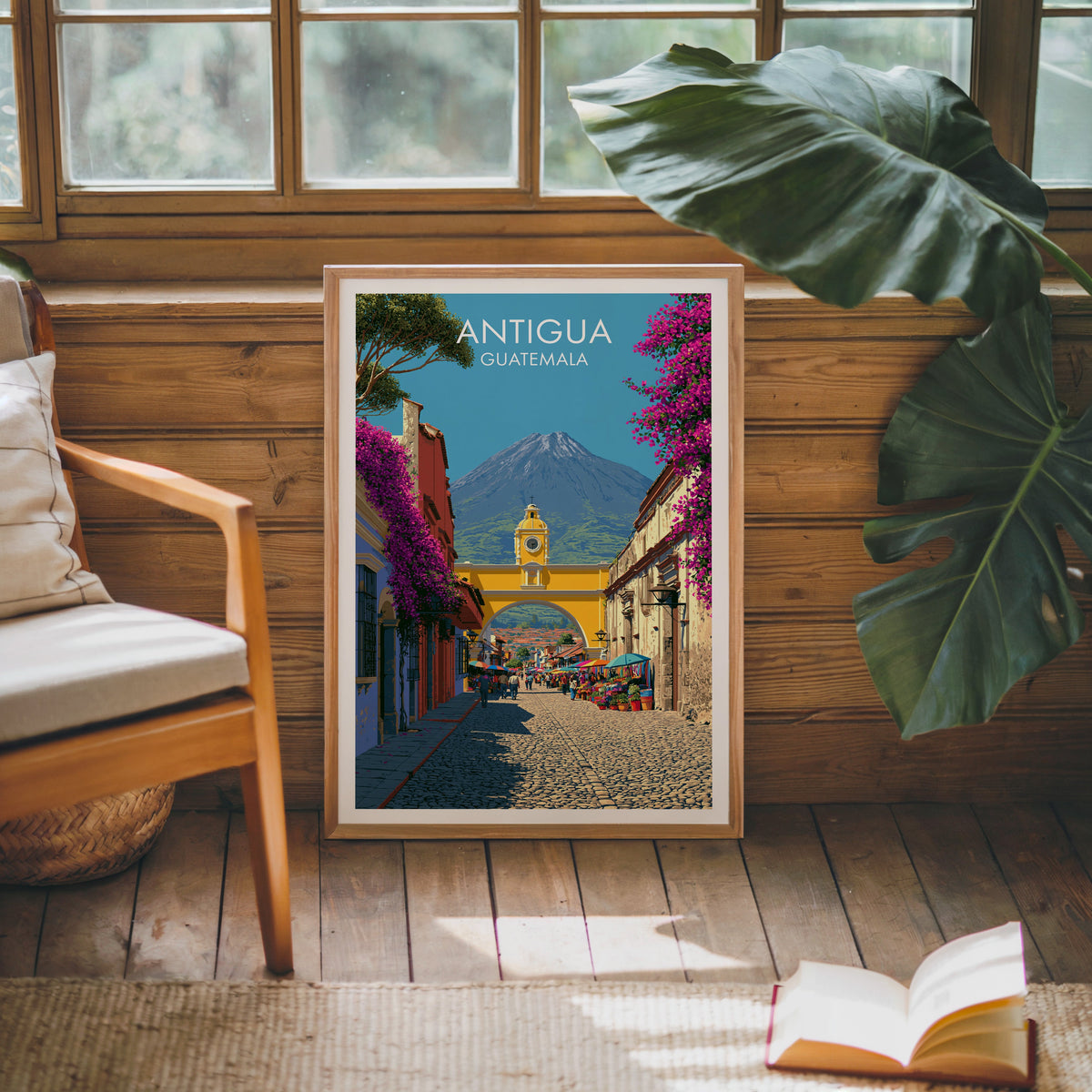 Guatemala arch print in an oak frame leaning on a pine cabin wall beside a wooden armchair, monstera and jute rug