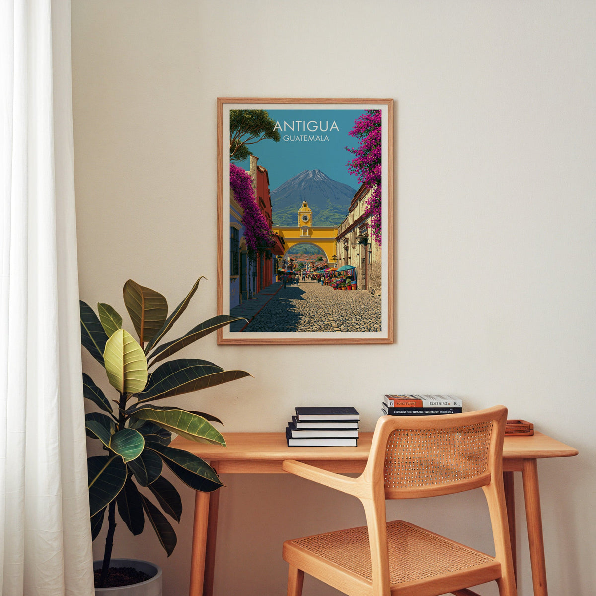 Central America travel print in an oak frame above a home-office desk with a cane chair and a rubber plant
