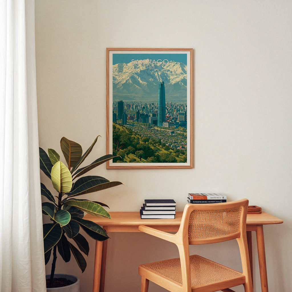 Santiago Chile travel art in an oak frame above a wood desk with cane chair, books and a rubber plant in a home office
