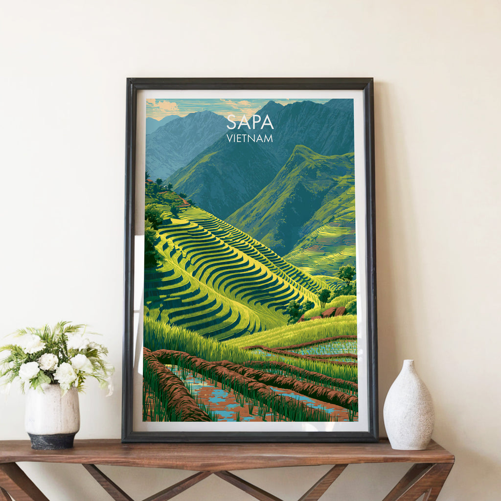 Sapa Vietnam travel poster in a black frame on a wooden console table with white flowers