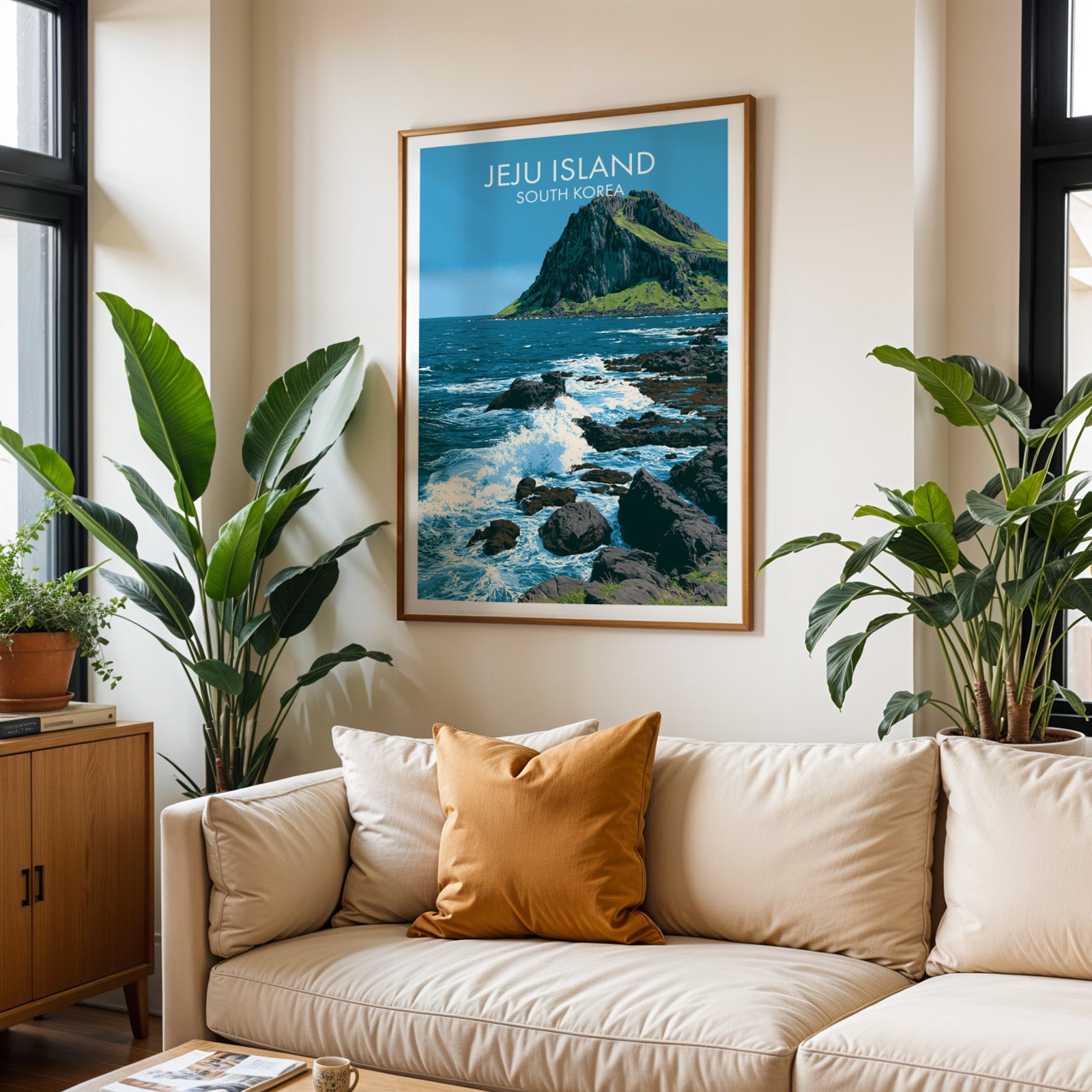Framed Seongsan Ilchulbong Jeju Korea wall art hanging above a cream sofa in a bright living room with tropical plants