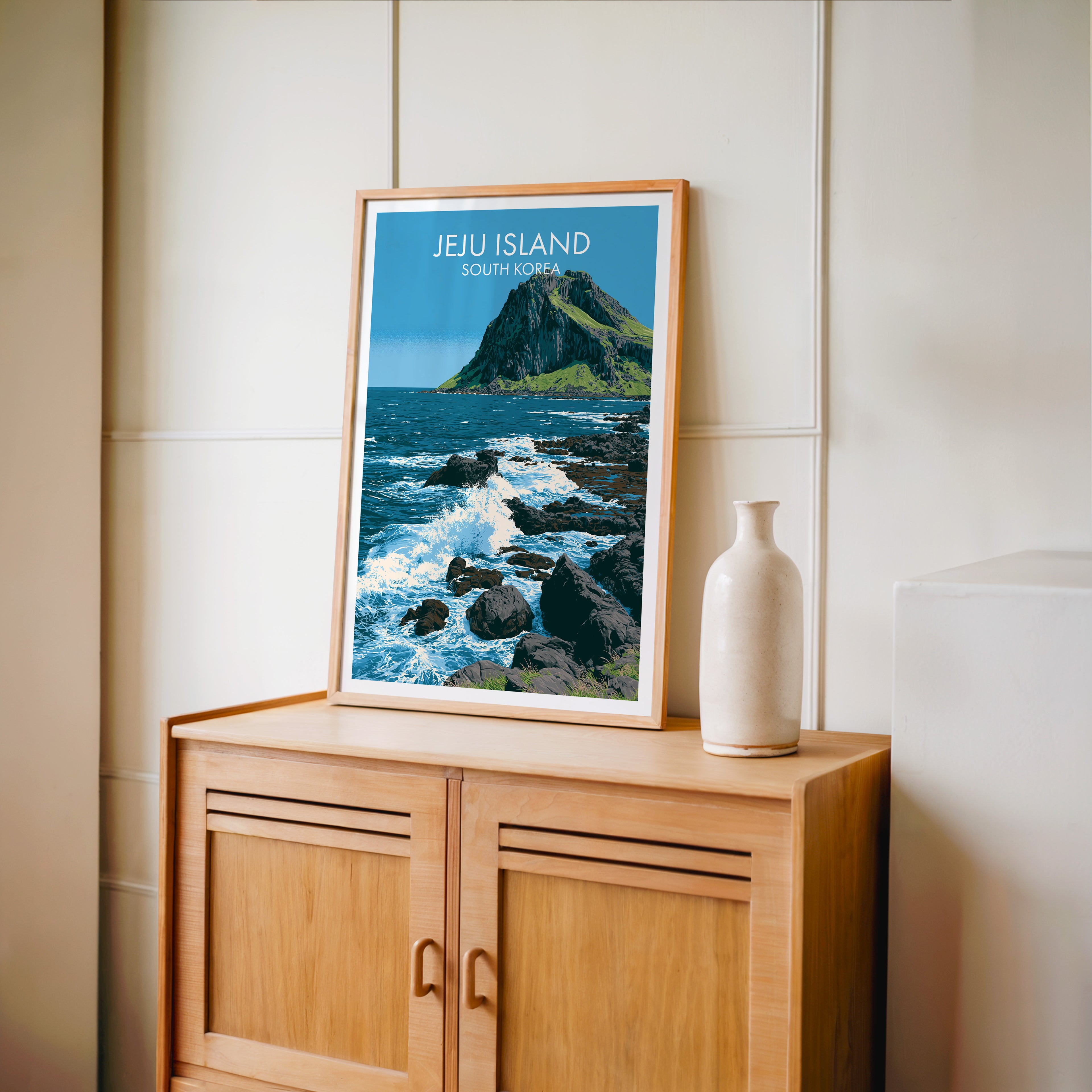 Small Seongsan Ilchulbong Jeju Korea travel poster in an oak frame on a mid-century sideboard with a ceramic vase