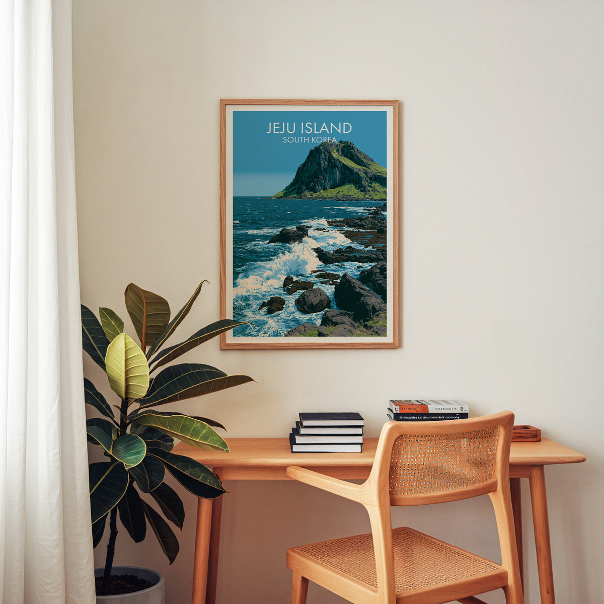 Seongsan tuff cone seascape print in an oak frame above a wooden home office desk with a cane chair and books