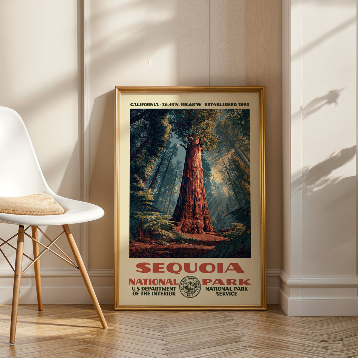 Sequoia National Park vintage WPA art in an oak frame leaning by a white chair on a wood floor