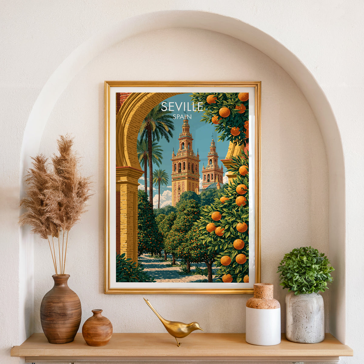 Seville Giralda print in a gold frame in an arched plaster alcove with pampas grass and a brass bird