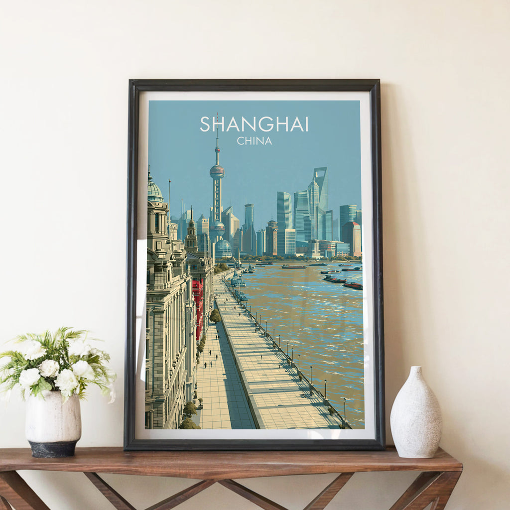 Shanghai China travel poster in a black frame on a wooden console table with white flowers