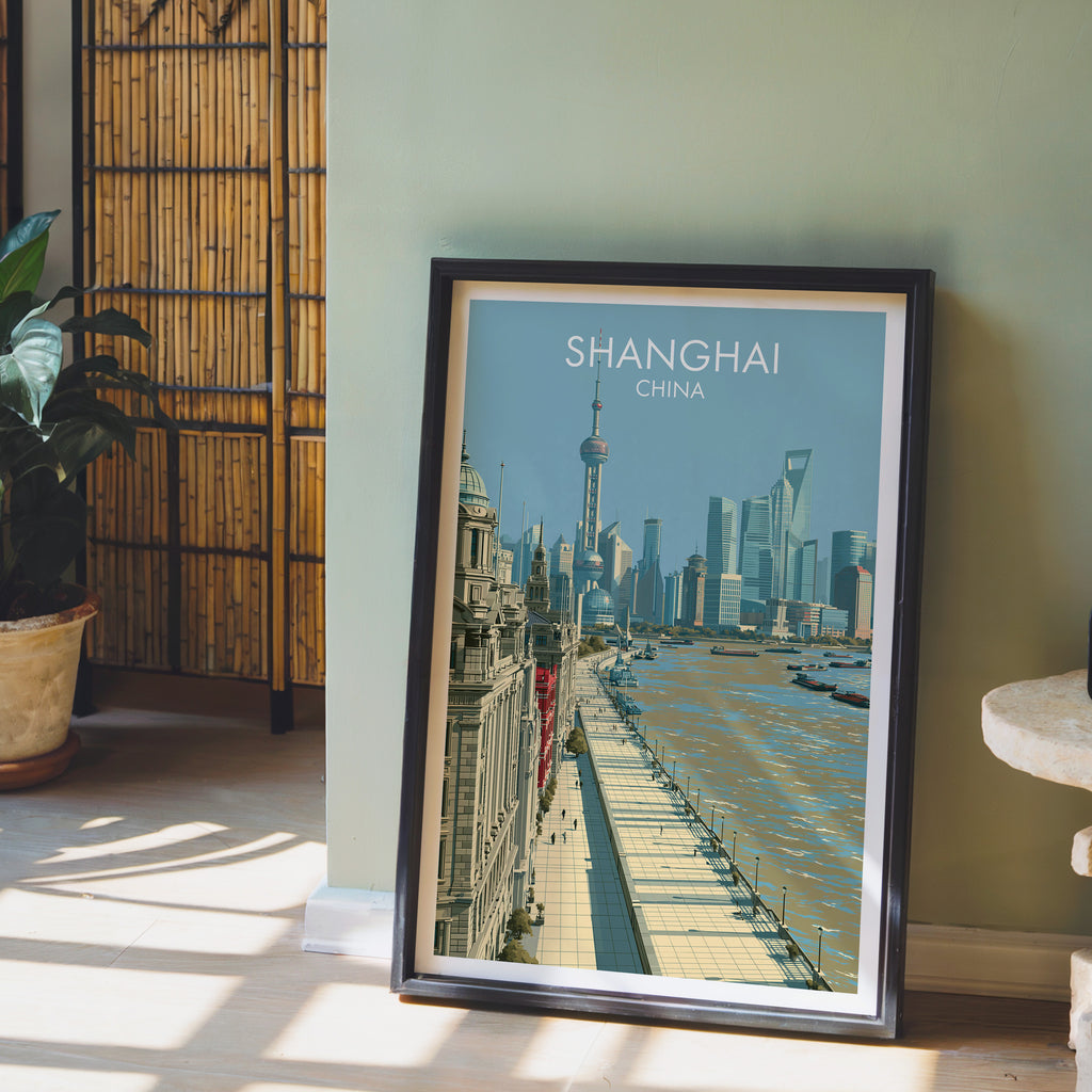 Shanghai China wall art in a black frame leaning against a sage green wall beside a bamboo screen