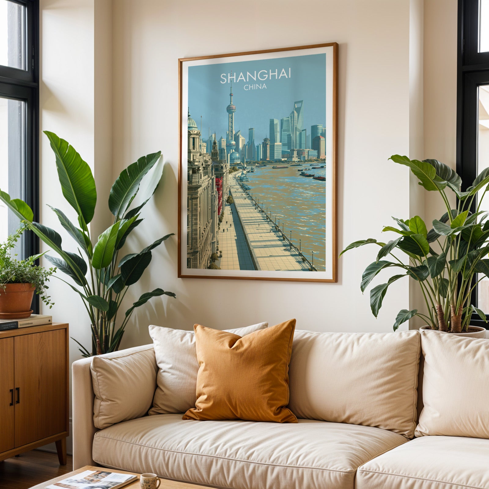 Framed Shanghai China wall art hanging above a cream sofa in a bright living room with tropical plants