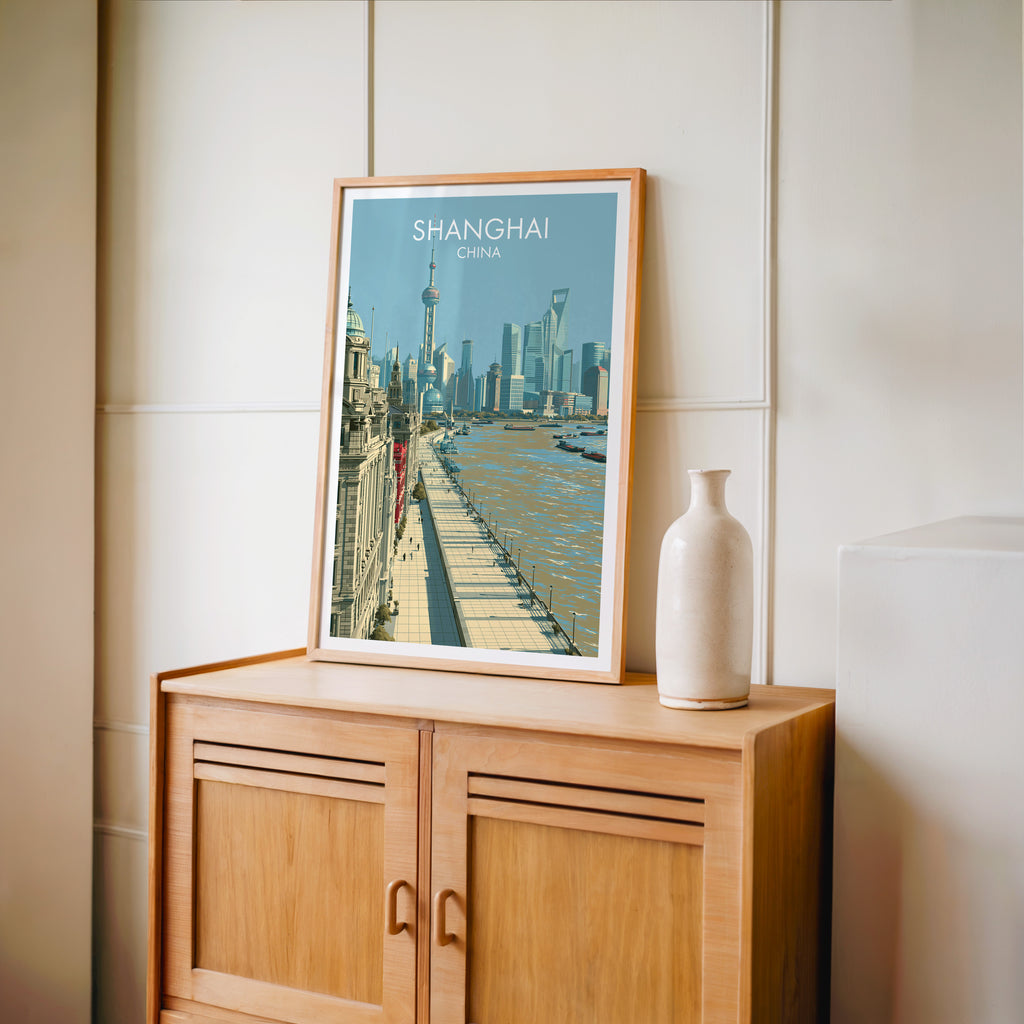 Small Shanghai China travel poster in an oak frame on a mid-century sideboard with a ceramic vase