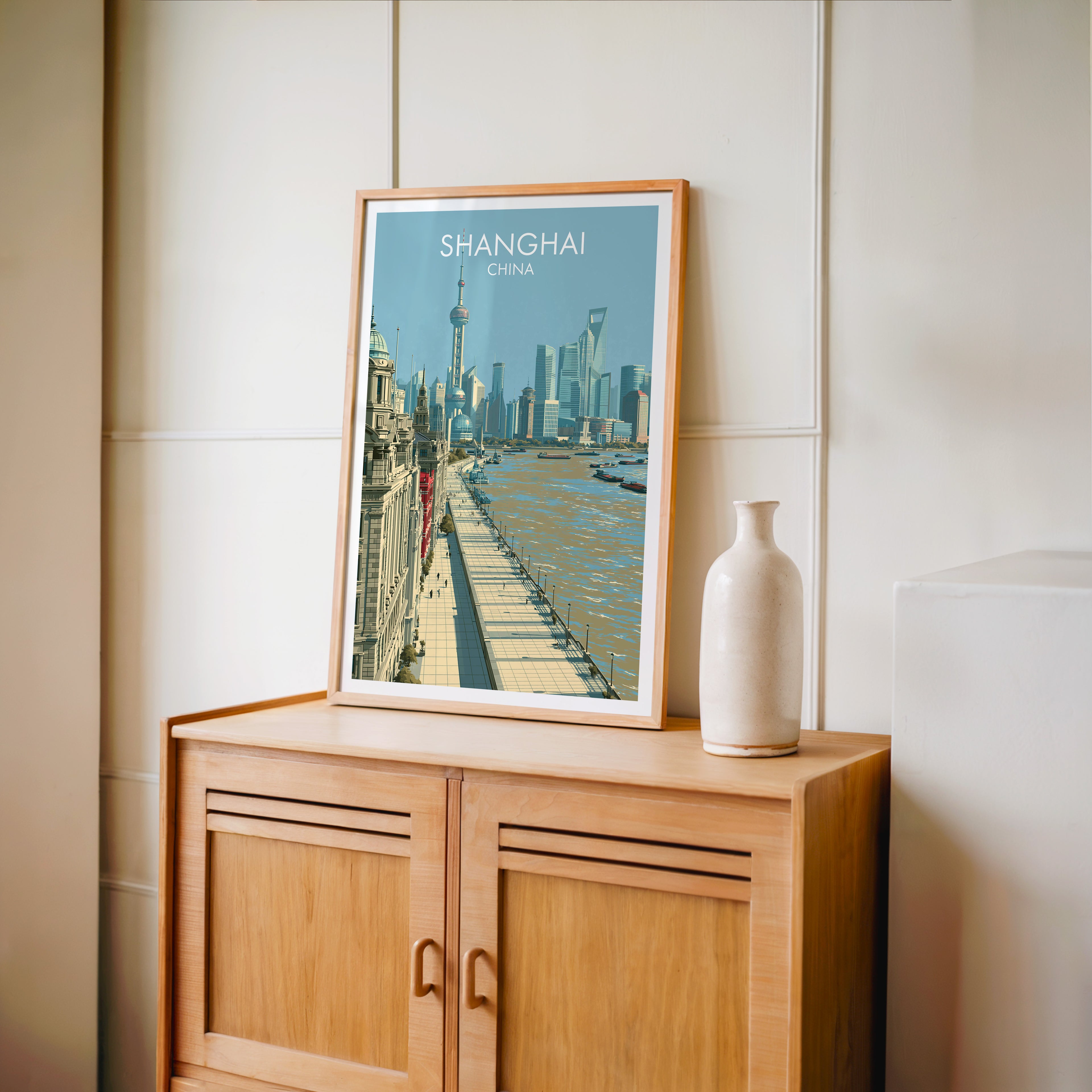 Small Shanghai China travel poster in an oak frame on a mid-century sideboard with a ceramic vase