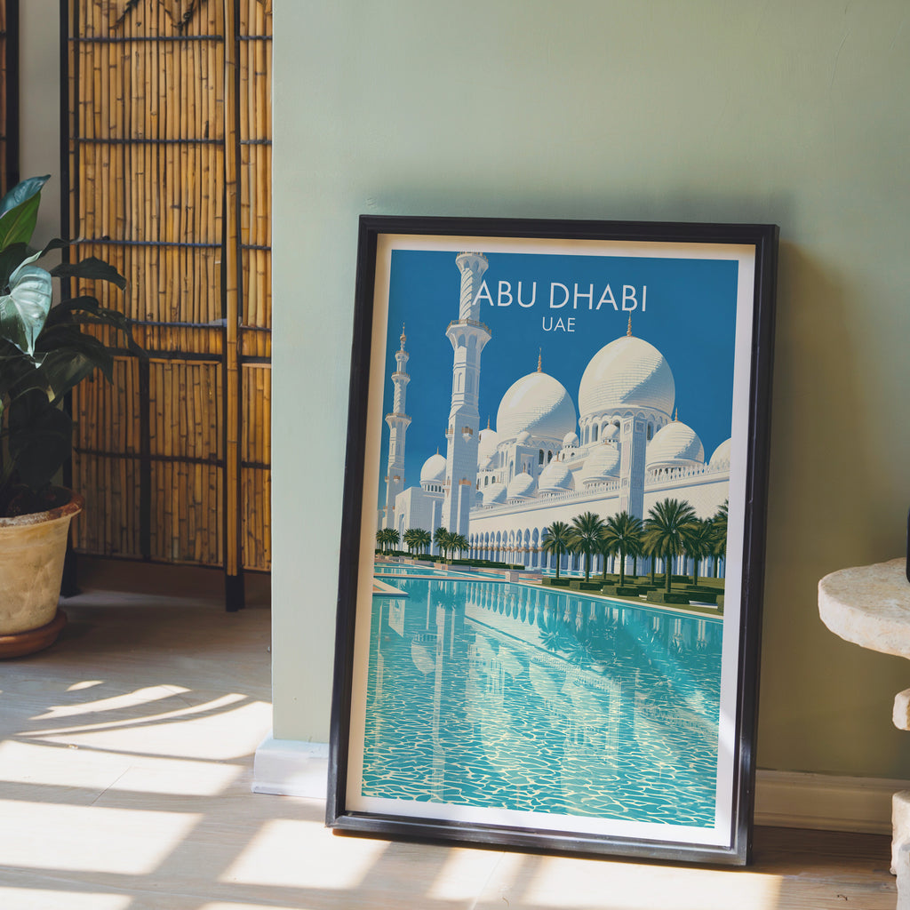 Sheikh Zayed Mosque Abu Dhabi wall art in a black frame leaning against a sage green wall beside a bamboo screen
