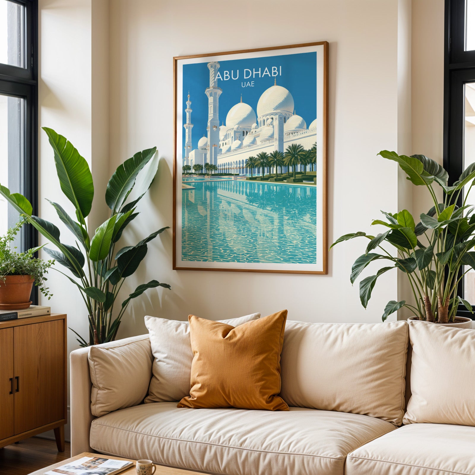 Framed Sheikh Zayed Mosque Abu Dhabi wall art hanging above a cream sofa in a bright living room with tropical plants
