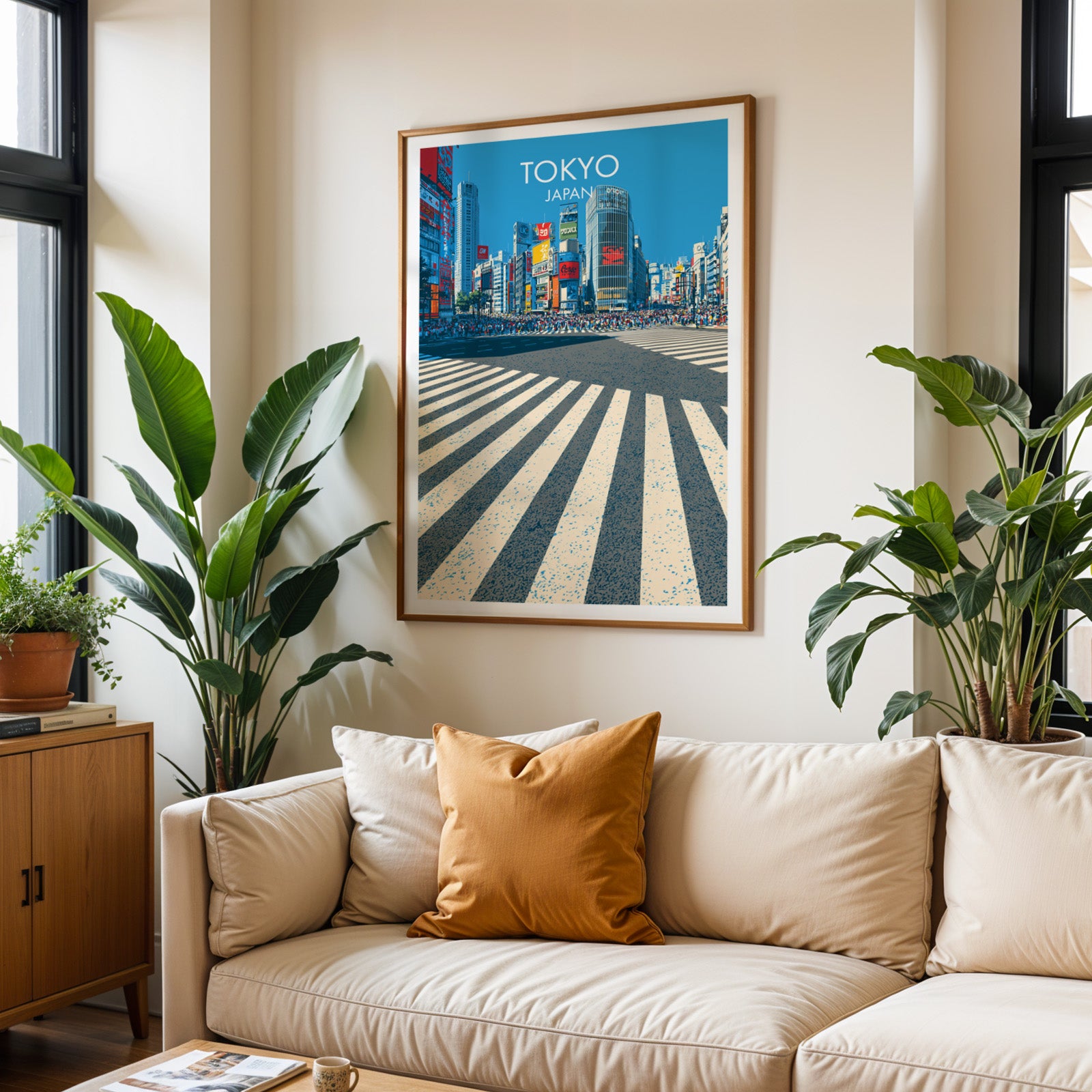 Framed Shibuya Crossing Tokyo Japan wall art hanging above a cream sofa in a bright living room with tropical plants