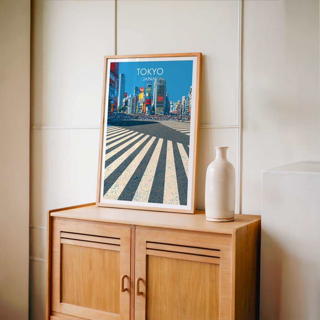 Small Shibuya Crossing Tokyo Japan travel poster in an oak frame on a mid-century sideboard with a ceramic vase