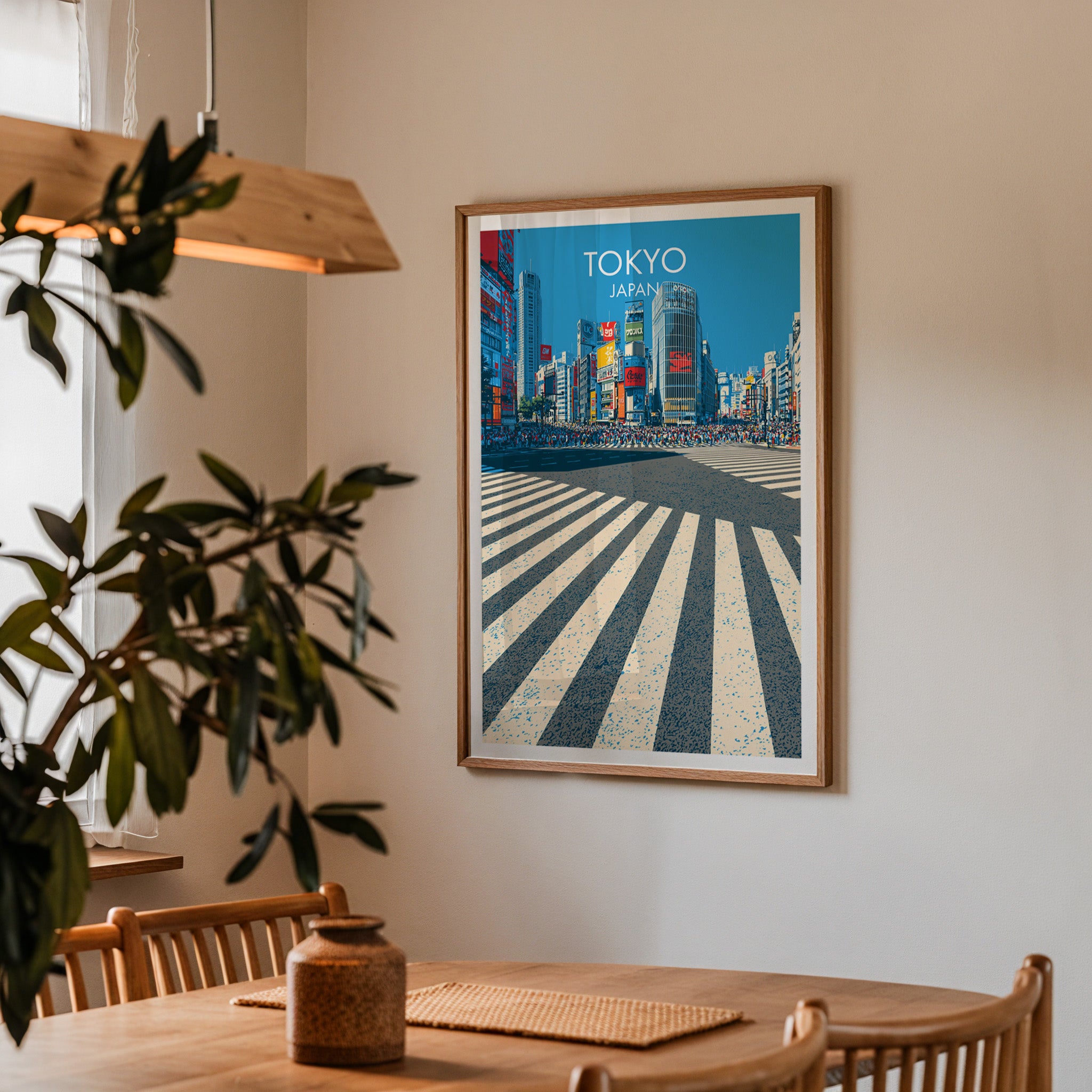 Framed Shibuya Crossing Tokyo Japan print on a dining room wall above an oak table in warm afternoon light