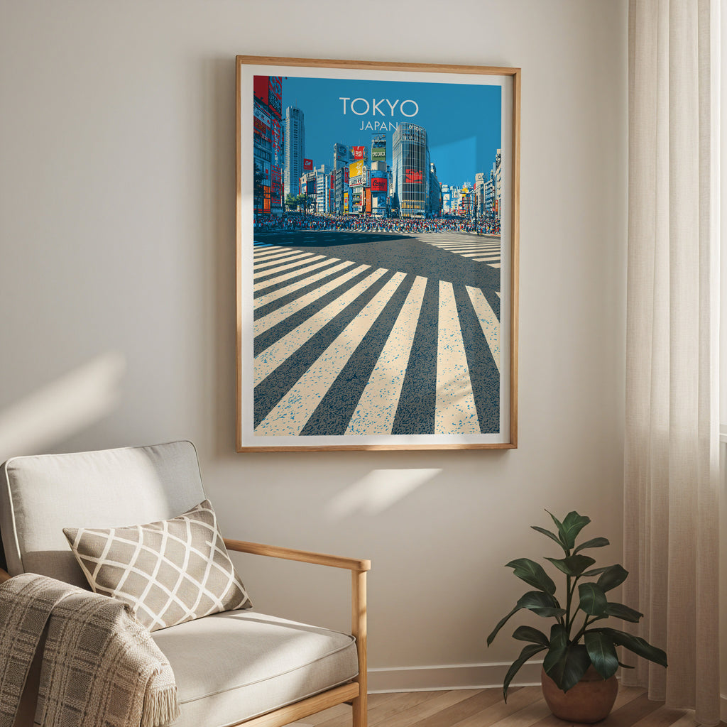 Shibuya Crossing Tokyo Japan travel print in a light oak frame on a living room wall beside a linen armchair