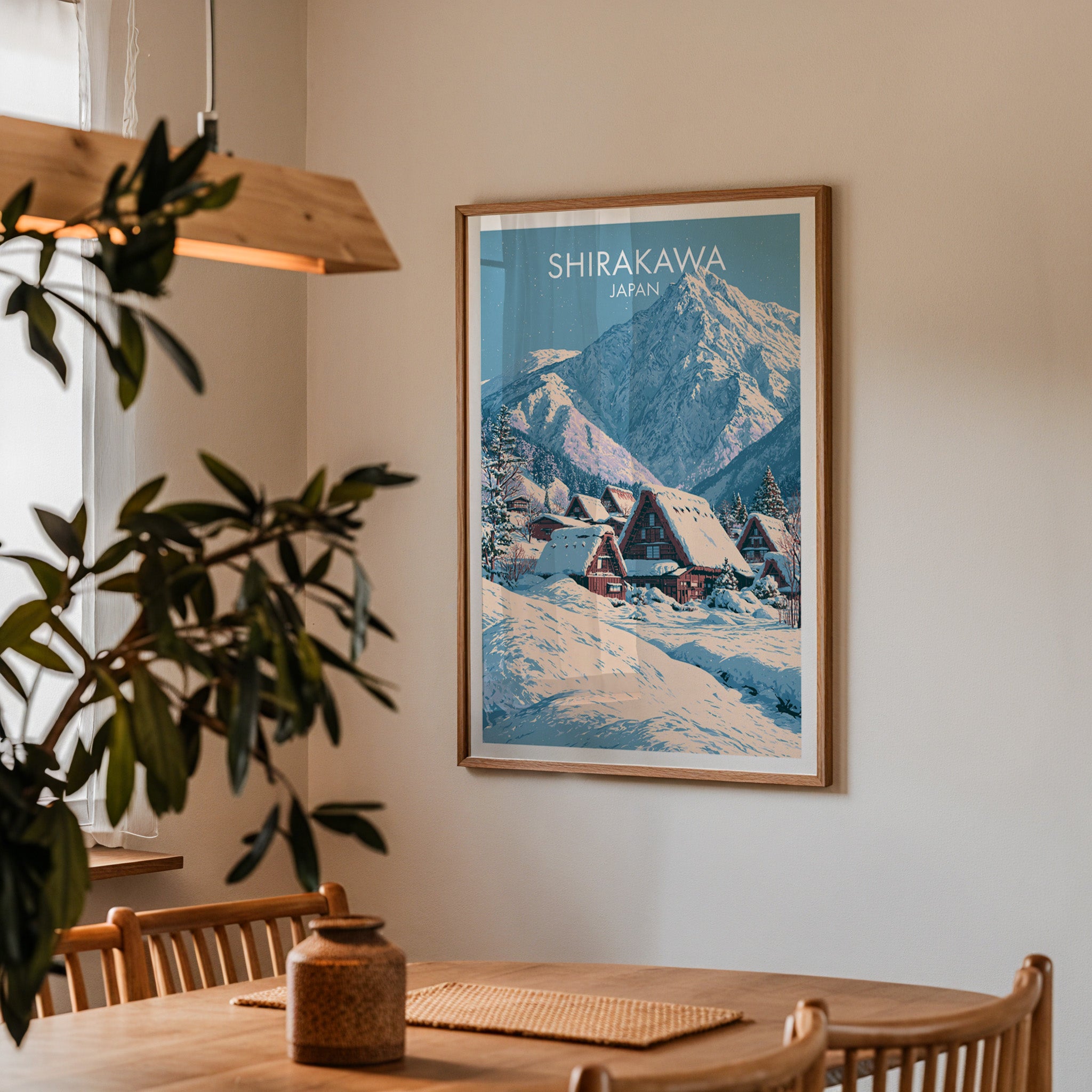 Framed Shirakawa go Japan print on a dining room wall above an oak table in warm afternoon light