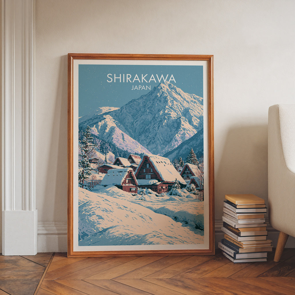 Shirakawa go Japan art print in a walnut frame leaning in a hallway beside stacked books
