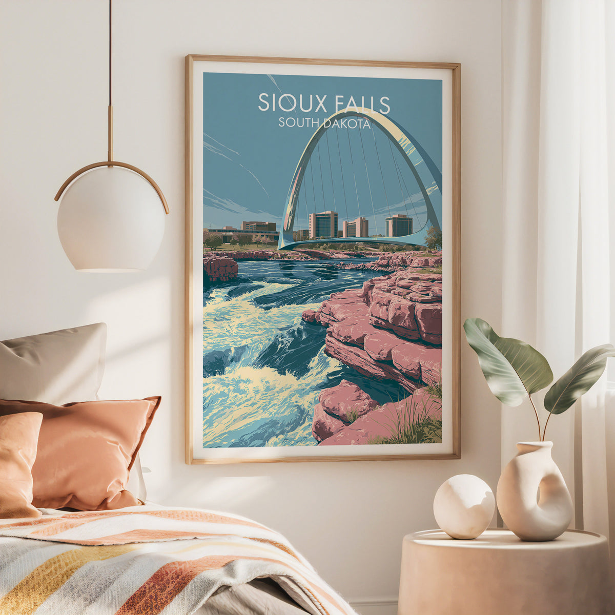 Large oak framed Sioux Falls poster over a bed with rust bedding and a hanging brass lamp