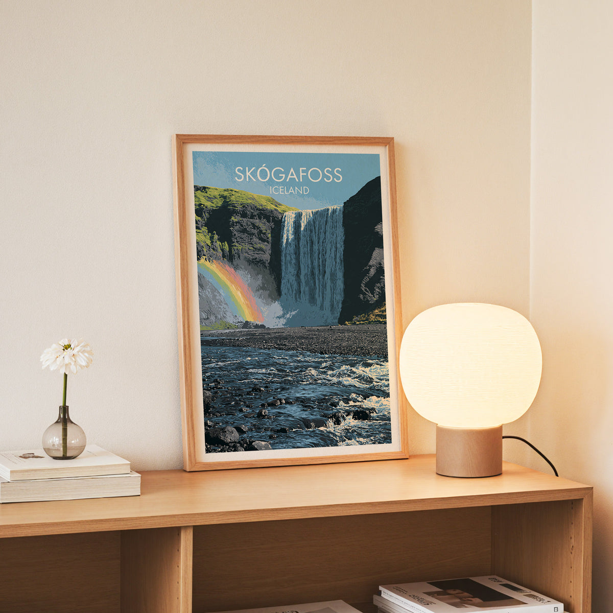 Iceland waterfall wall art, slim oak frame on an oak console beside a daisy in a glass bottle