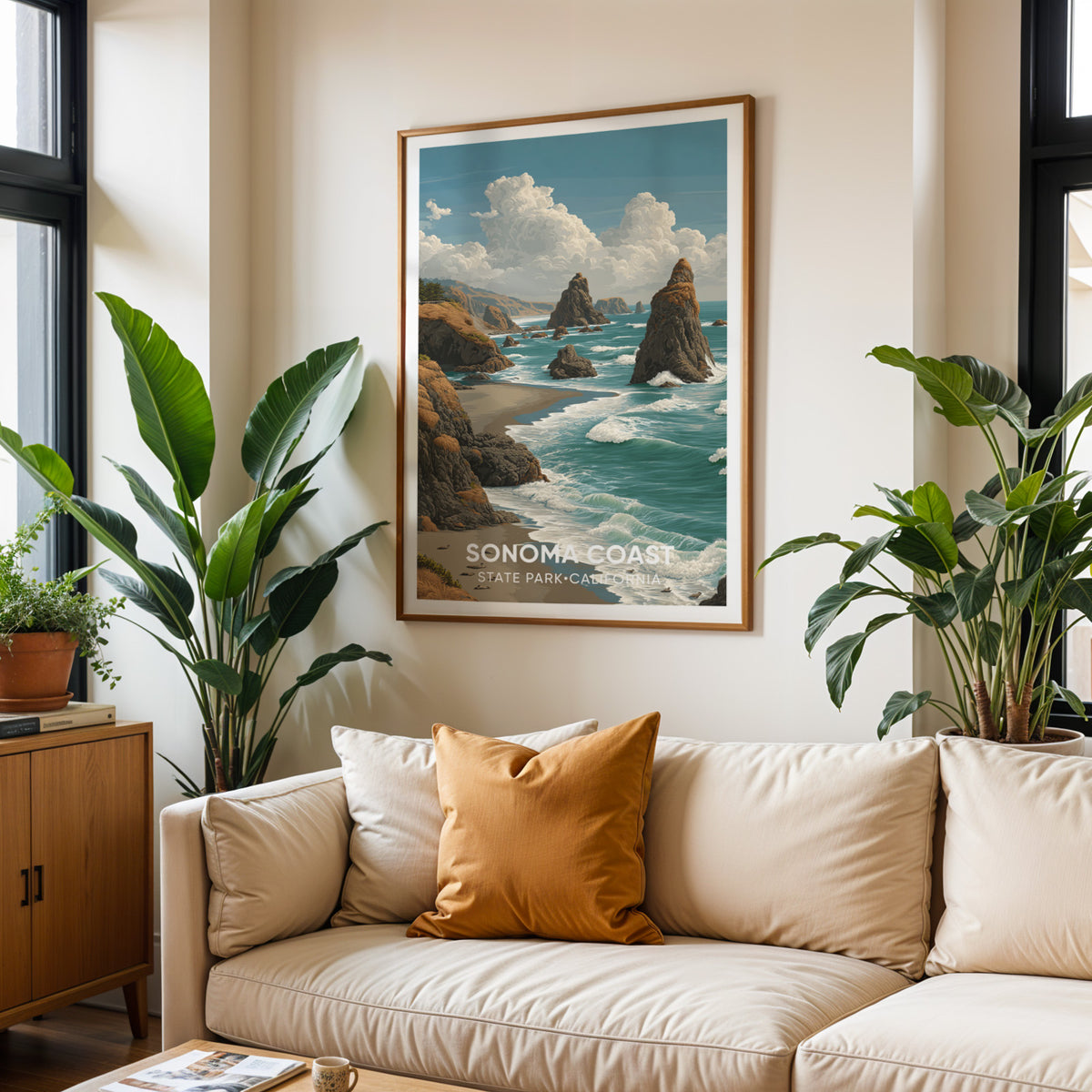 Sonoma Coast wall art above a cream sofa with terracotta cushions and tall tropical plants