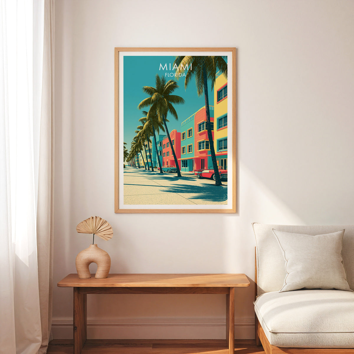 Miami Florida poster in an oak frame over a slim wood bench, cream armchair and linen curtain