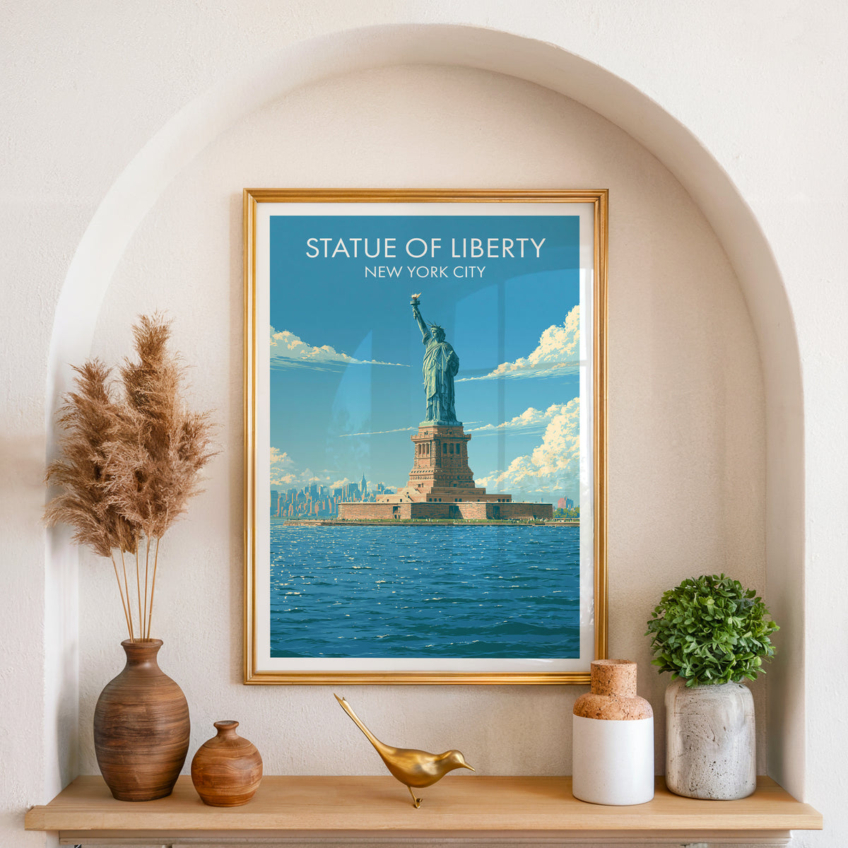 Liberty Island harbor print in a gold frame in an arched wall niche with pampas grass and a brass bird.