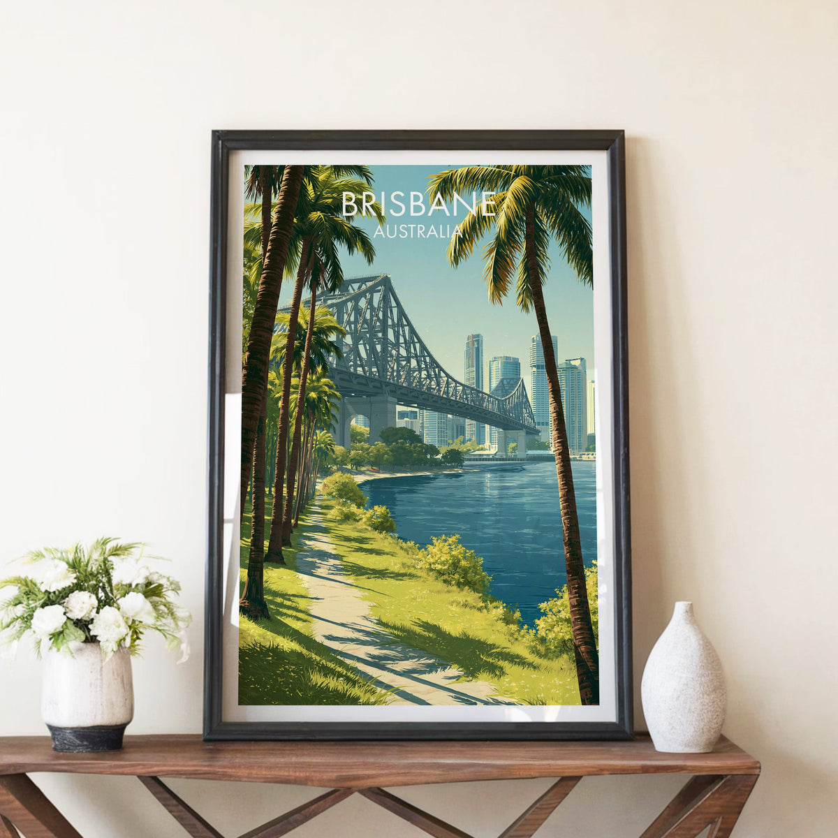 Brisbane Story Bridge poster in a black frame on a walnut console with white peonies and a stone vase