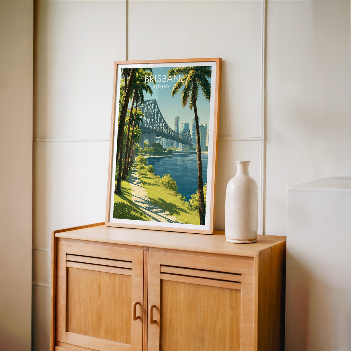 Story Bridge print in an oak frame on a light oak cabinet against a cream panelled wall
