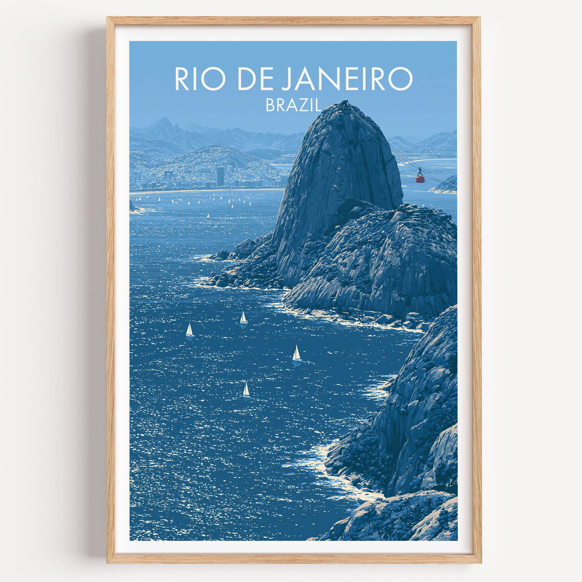 Sugarloaf Mountain travel poster in blue with the granite dome and red cable car, light oak frame on a white wall