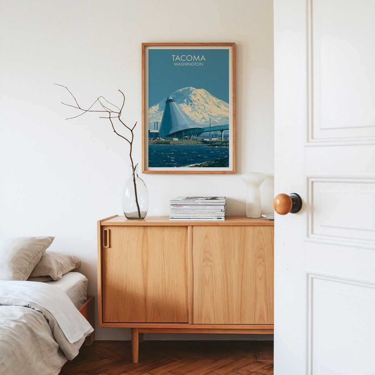 Tacoma waterway poster in an oak frame on a bright oak sideboard with dried stems, magazines and a white vase.