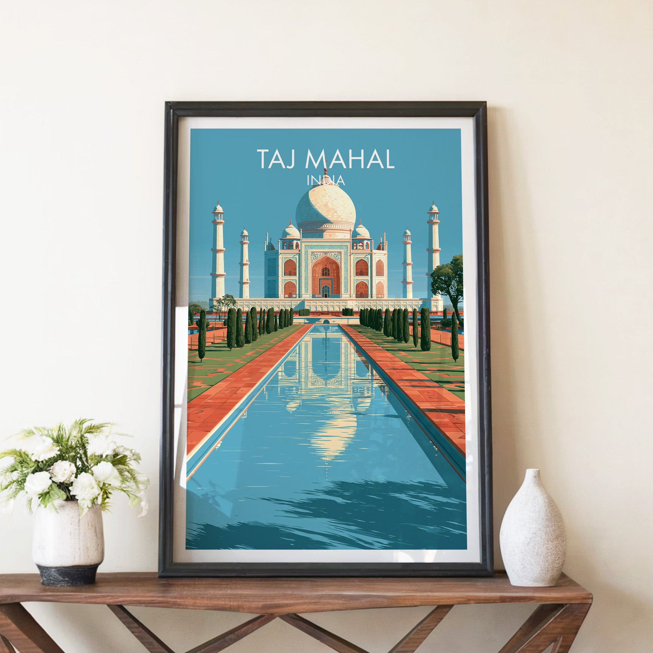 Taj Mahal Agra India travel poster in a black frame on a wooden console table with white flowers