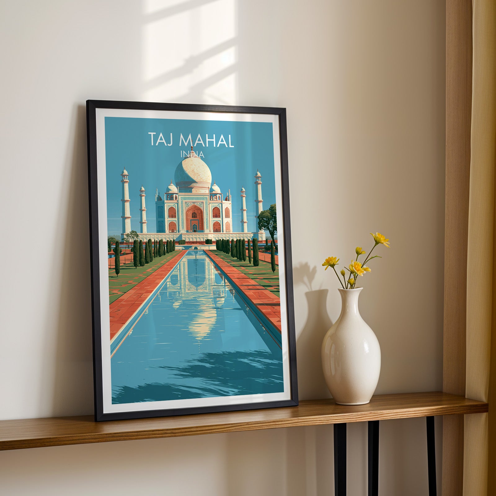 Black framed Taj Mahal Agra India print on a narrow hallway console in sunlight, styled with yellow flowers