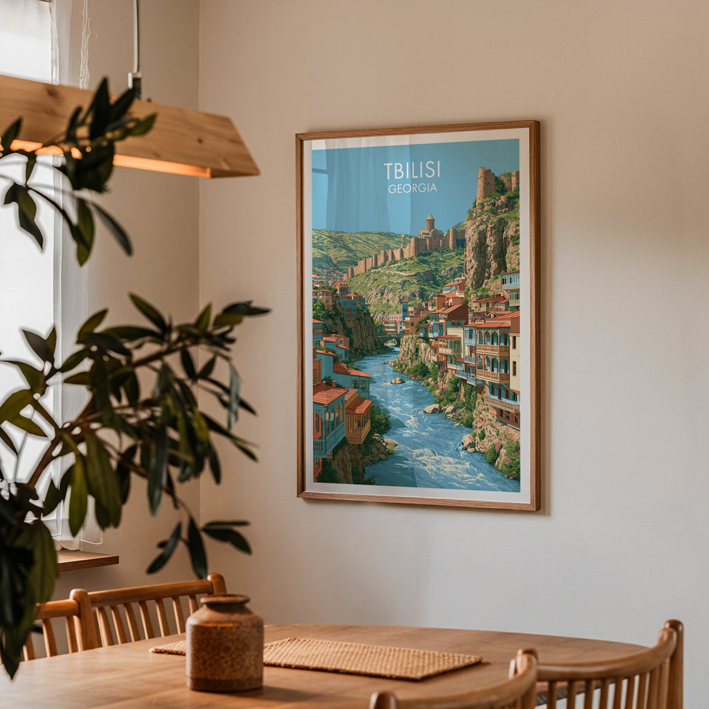 Framed Tbilisi Georgia print on a dining room wall above an oak table in warm afternoon light