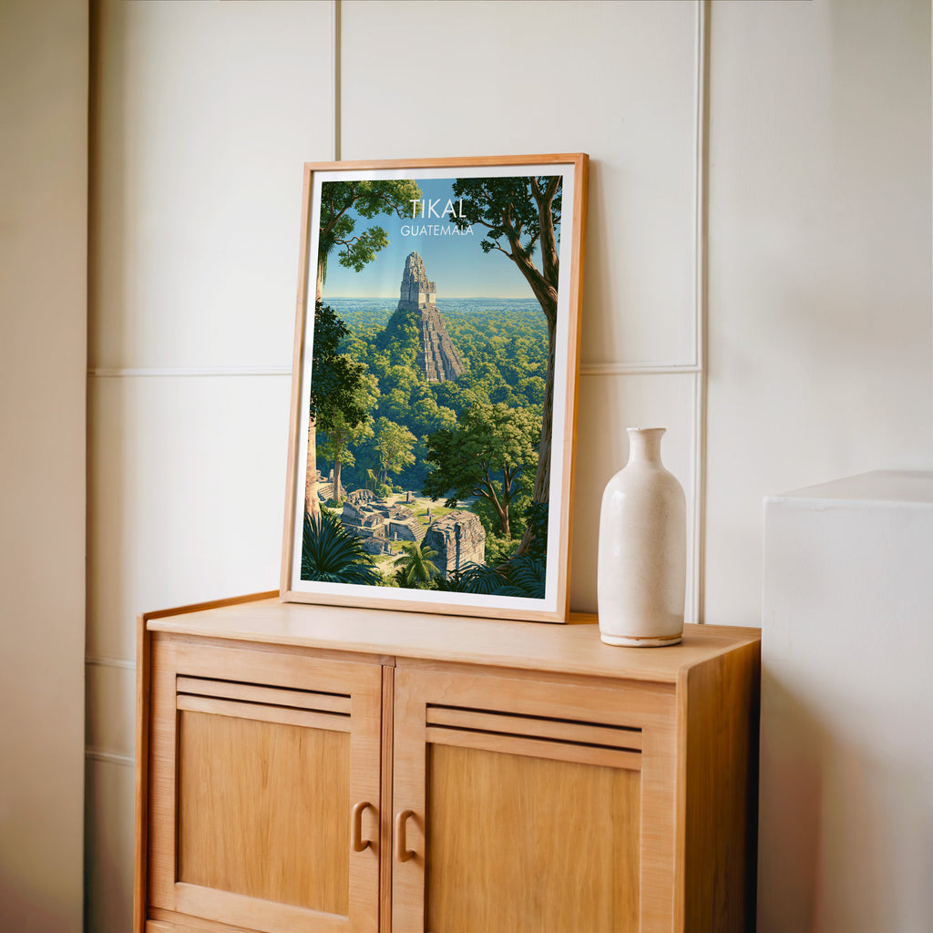 Carved stela and palms in an oak frame on a light oak cabinet, cream panelled wall and a pale bottle vase