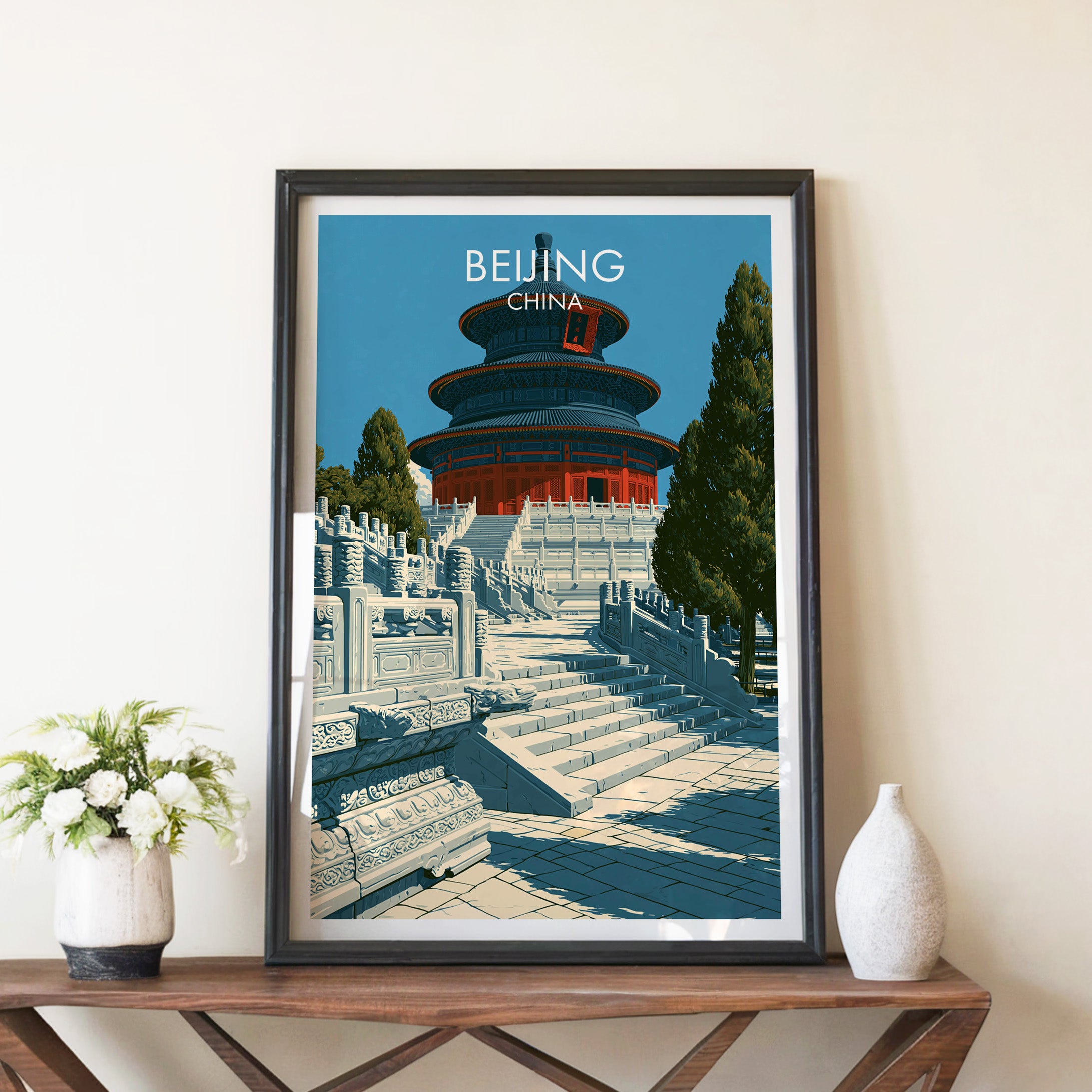 Temple of Heaven Beijing travel poster in a black frame on a wooden console table with white flowers