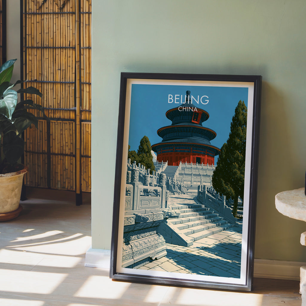 Temple of Heaven Beijing wall art in a black frame leaning against a sage green wall beside a bamboo screen