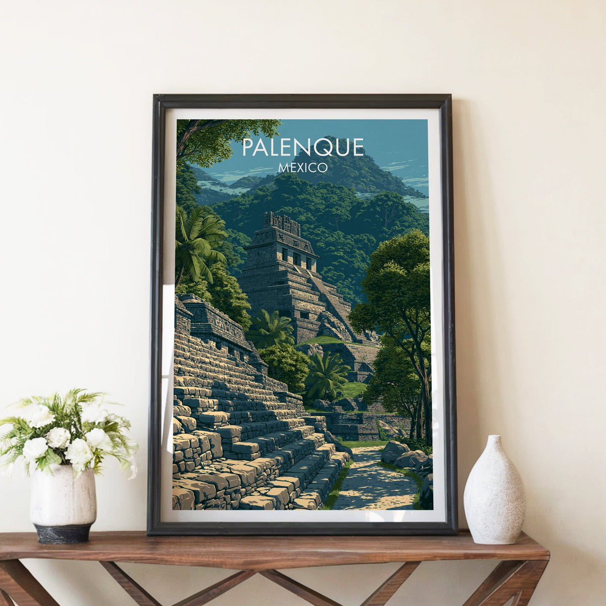 Palenque travel print in a black frame on a walnut console with white peonies and a white ceramic vase