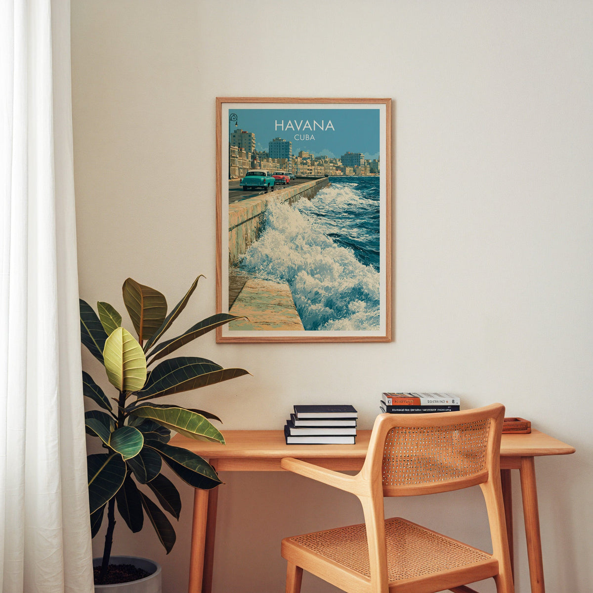 Cuba travel poster of the seawall in an oak frame above a home-office desk with a cane chair and rubber plant
