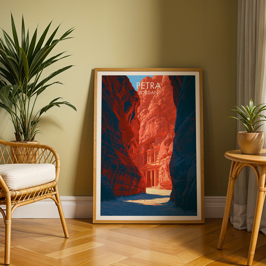 Large Petra Jordan Treasury travel print in an oak frame leaning on a herringbone floor next to a rattan chair