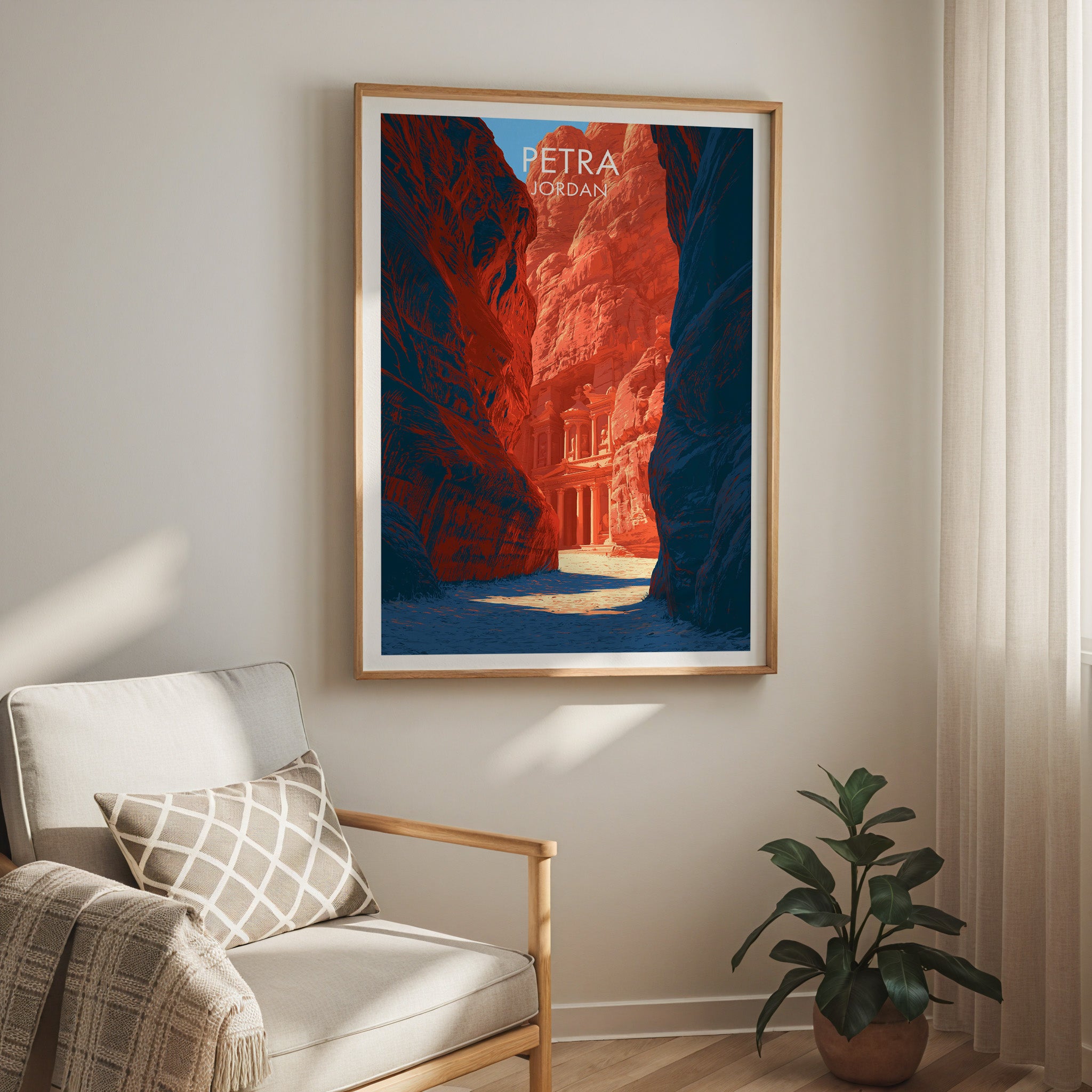 Petra Jordan Treasury travel print in a light oak frame on a living room wall beside a linen armchair