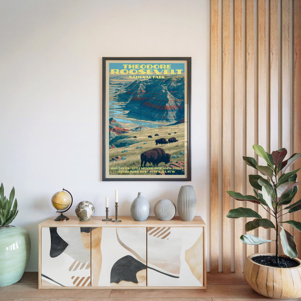 Theodore Roosevelt National Park print in a black frame above a light wood sideboard by a slatted panel