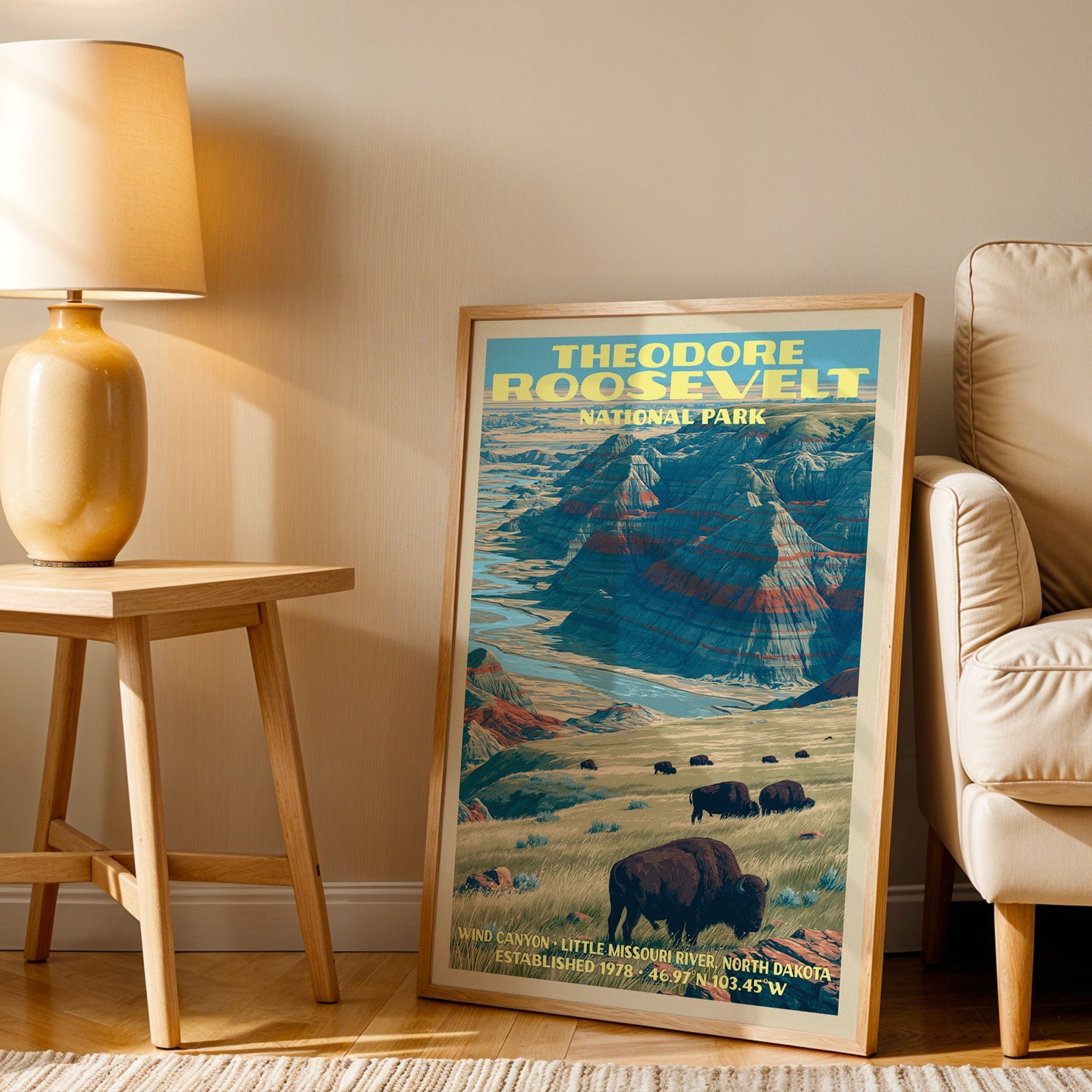 Wind Canyon bison wall art in oak, leaning by an armchair and a side table with an ochre ceramic lamp