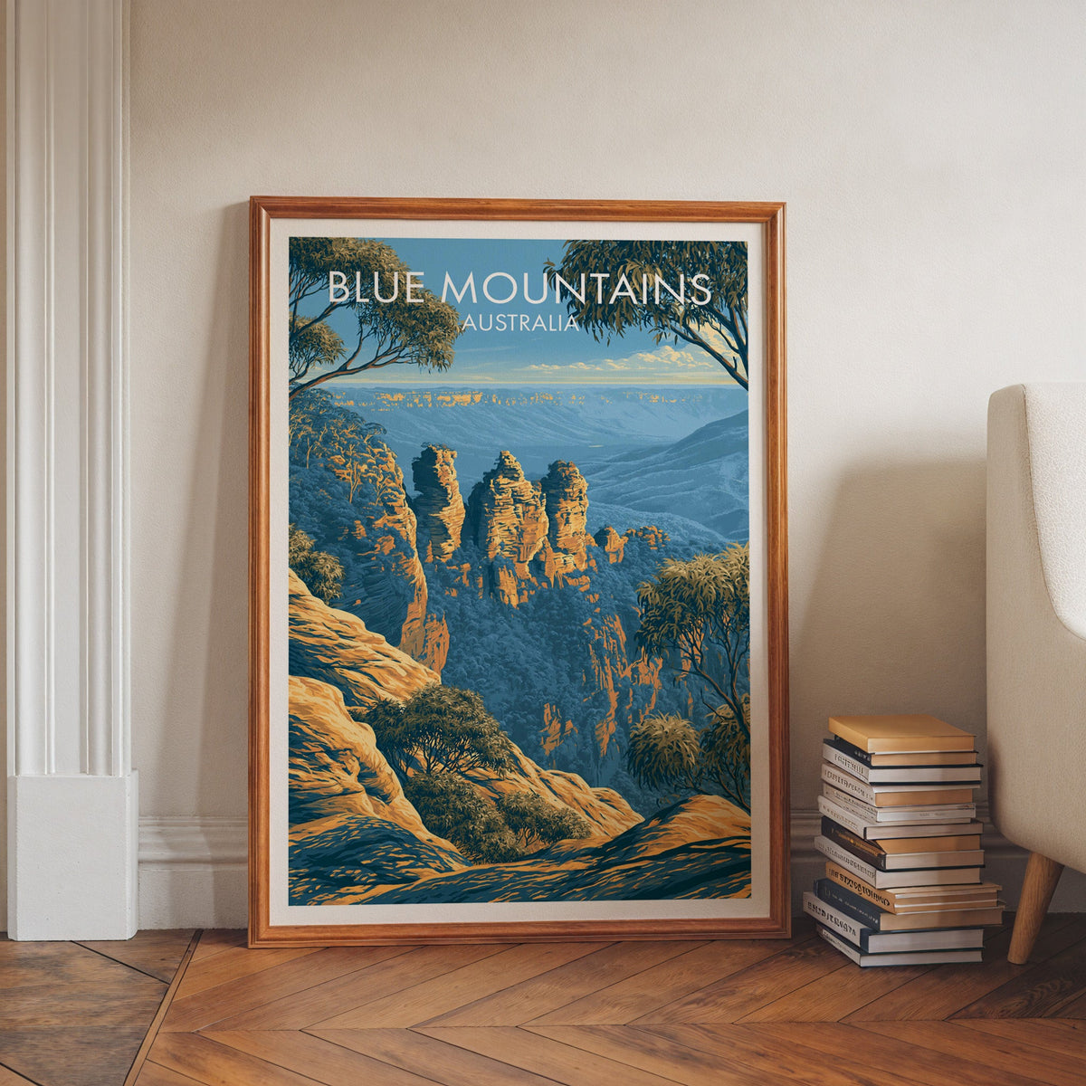 Blue Mountains print in a walnut frame on herringbone floor beside stacked books and an armchair