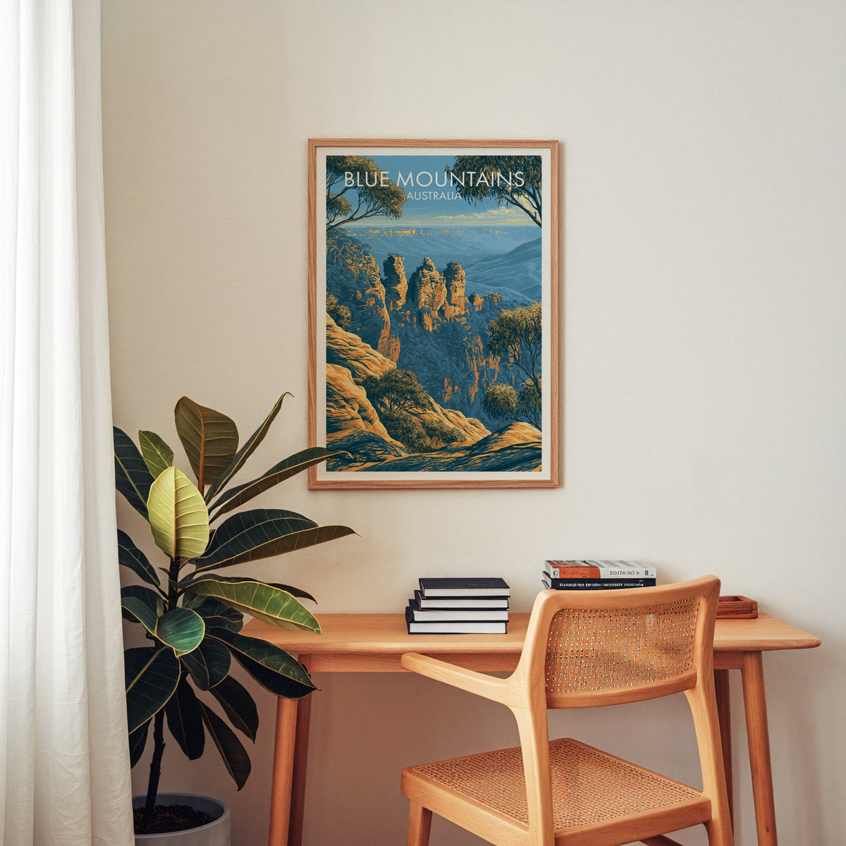 Three Sisters wall art in an oak frame above a home-office desk with a cane chair and rubber plant