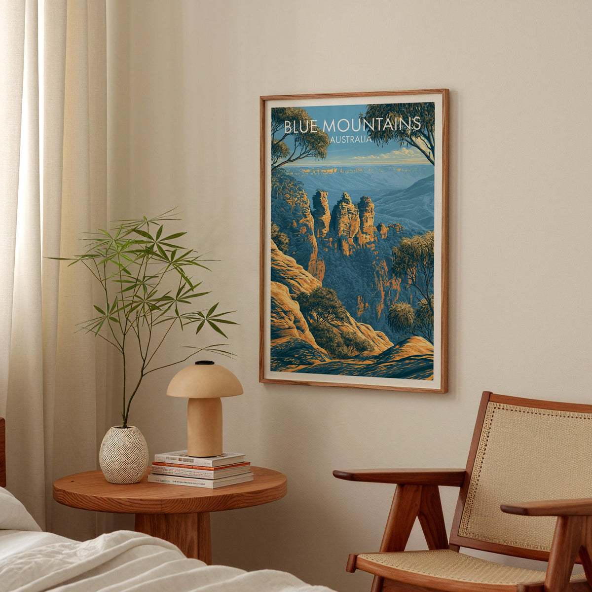Blue Mountains artwork framed in a bedroom above a bedside table with a mushroom lamp and bamboo