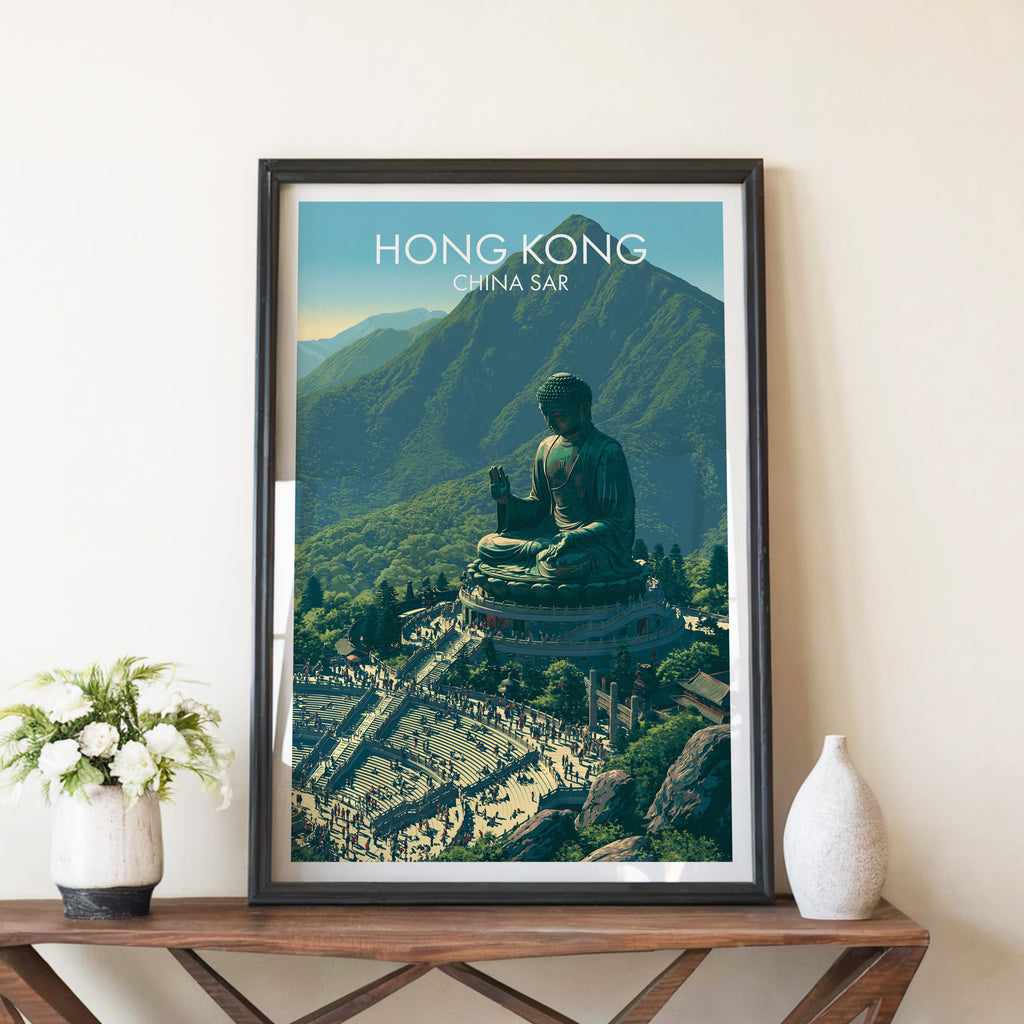 Tian Tan Big Buddha Hong Kong travel poster in a black frame on a wooden console table with white flowers