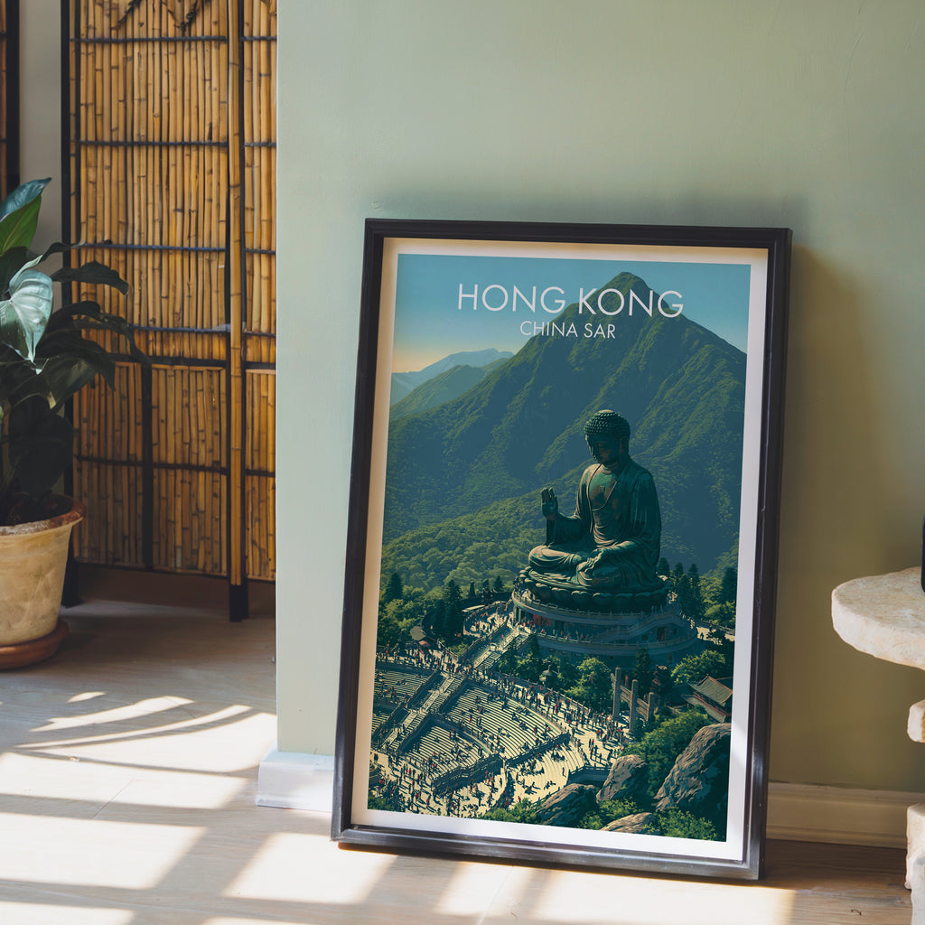 Tian Tan Big Buddha Hong Kong wall art in a black frame leaning against a sage green wall beside a bamboo screen
