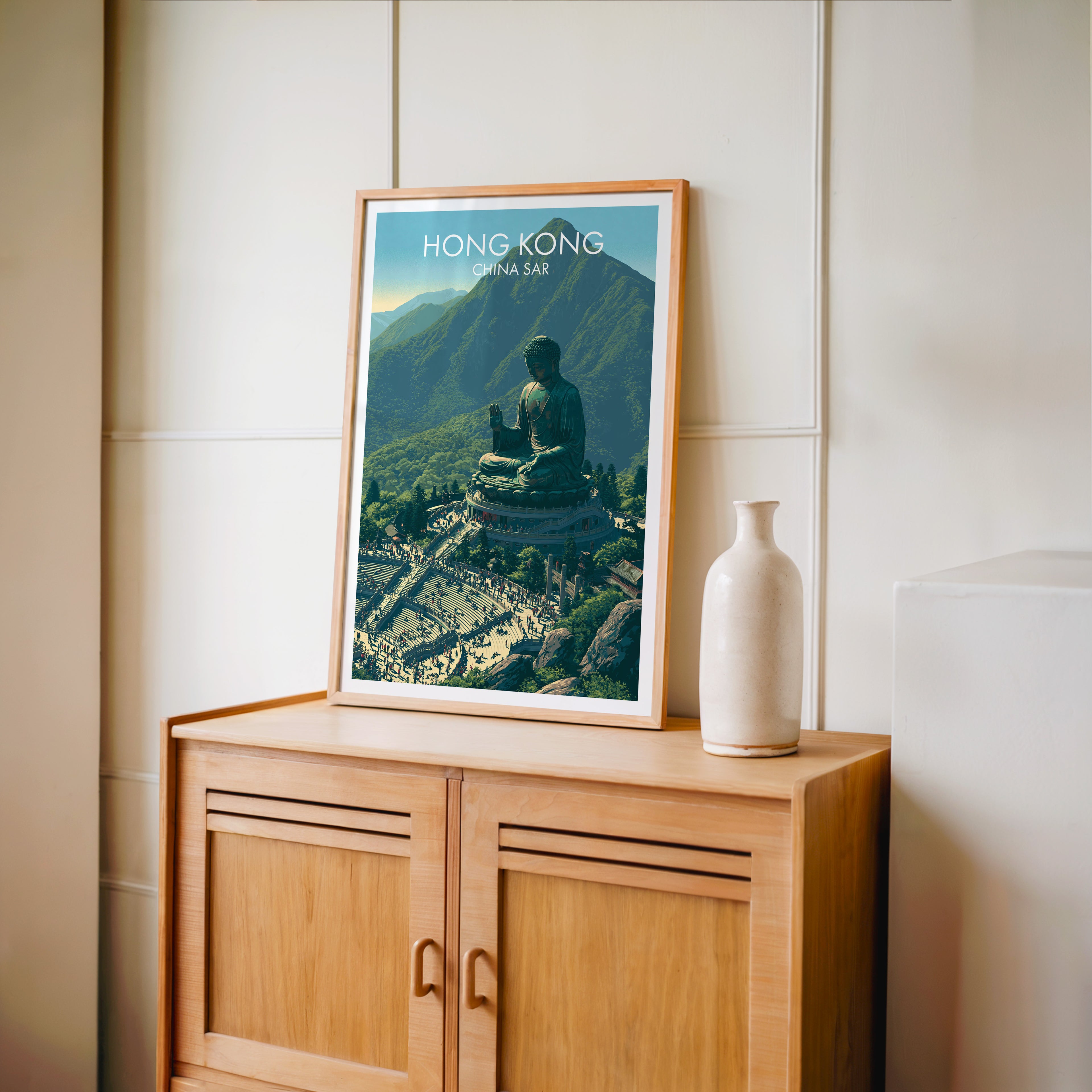Small Tian Tan Big Buddha Hong Kong travel poster in an oak frame on a mid-century sideboard with a ceramic vase
