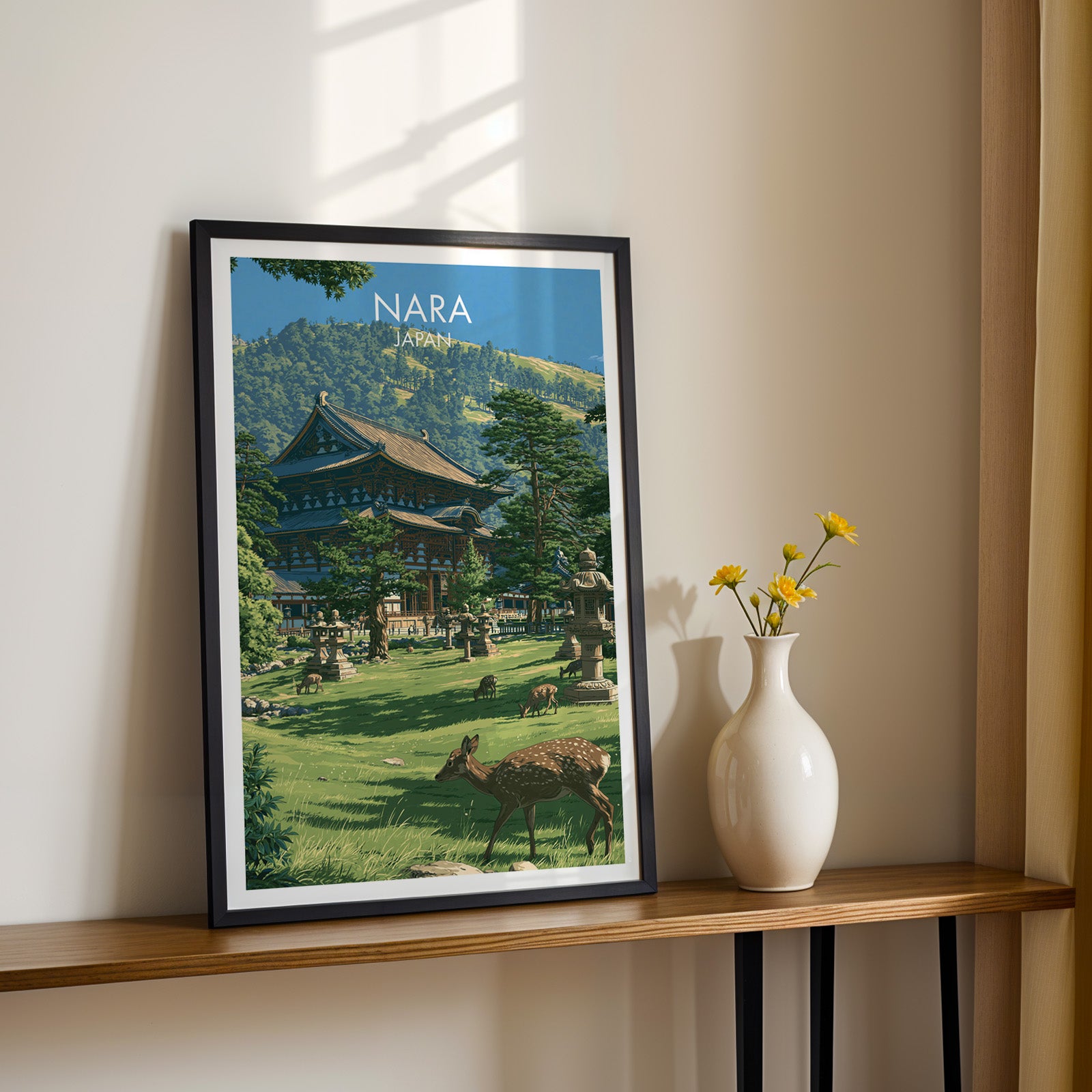 Black framed Todai ji Temple Nara Japan print on a narrow hallway console in sunlight, styled with yellow flowers
